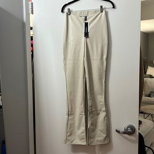 Vegan leather flare leggings. New with tags size 4. Dipped waist & split hem